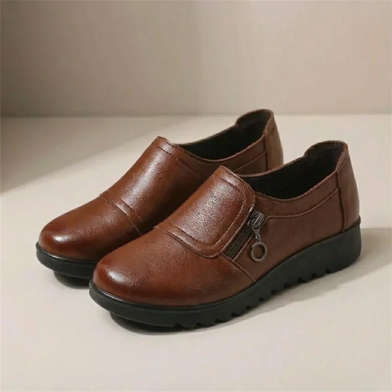 Paire de mocassins femme compensés marron en simili cuir avec zip latéral, vue de trois quarts.