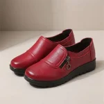 Paire de mocassins femme compensés rouges en simili cuir avec zip latéral, vue de trois quarts.