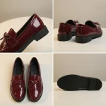 Une paire de mocassins en cuir verni rouge bordeaux brillant pour femme, disposés sur une surface ronde de couleur crème. Comme le modèle noir, ces chaussures possèdent un bout rond, un petit talon, un nœud décoratif et des franges sur le dessus, avec une finition brillante qui capte la lumière. La vue représente plusieurs angles de la chaussure