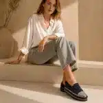 Femme portant un mocassin noir à strass et semelle épaisse avec une tenue élégante